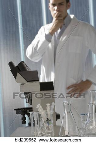 Pensive Caucasian scientist standing in laboratory View Large Photo Image Stock Image - Pensive Caucasian scientist standing in laboratory. Fotosearch