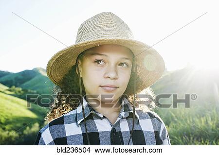 Picture - Pensive girl wearing hat on sunny hill. Fotosearch