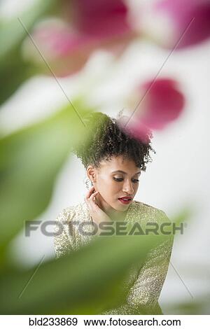 Pensive glamorous Black woman behind flowers View Large Photo Image Stock Photo - Pensive glamorous Black woman behind flowers. Fotosearch