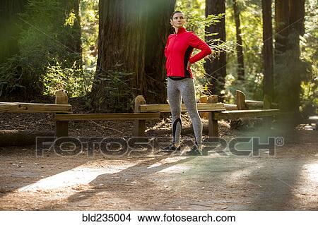 Picture - Pensive woman standing in forest. Fotosearch