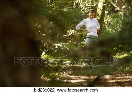 Pensive woman standing in forest View Large Photo Image Stock Image - Pensive woman standing in forest. Fotosearch