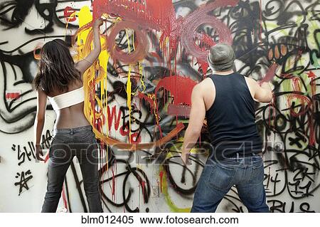Stock Photography - People tagging wall with graffiti. Fotosearch