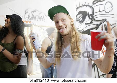 Stock Image - People tagging walls with graffiti. Fotosearch