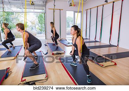 Picture - People using resistance bands in gymnasium. Fotosearch
