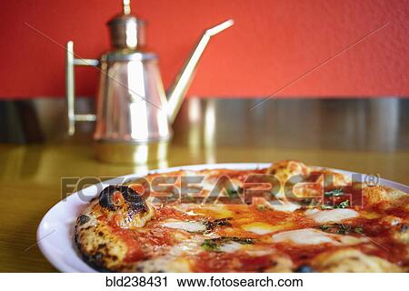 Pizza on plate in pizzeria View Large Photo Image Stock Image - Pizza on plate in pizzeria. Fotosearch