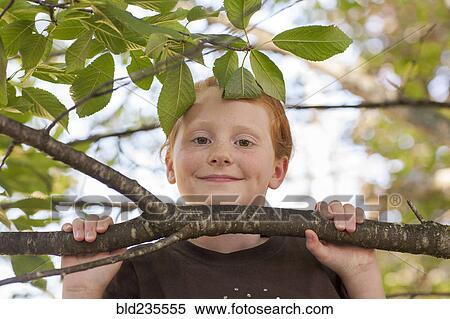 Stock Photography - Portrait of Caucasian girl holding tree branch. Fotosearch
