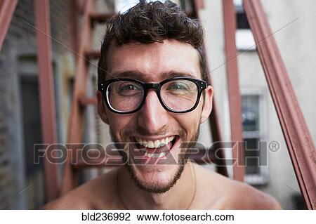 Stock Image - Portrait of Caucasian man on urban fire escape. Fotosearch