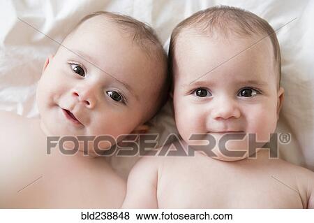 Stock Photo - Portrait of Caucasian twin baby girls. Fotosearch