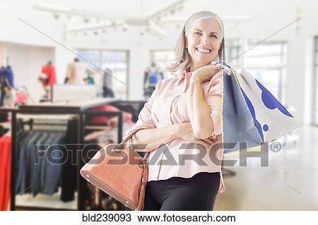 Portrait of Caucasian woman holding shopping bags View Large Photo Image Stock Image - Portrait of Caucasian woman holding shopping bags. Fotosearch