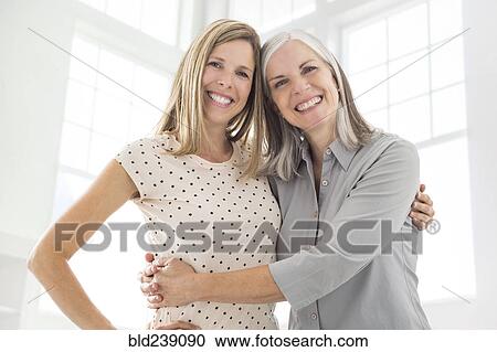 Stock Image - Portrait of Caucasian women hugging. Fotosearch