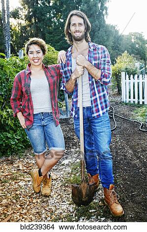 Picture - Portrait of couple posing with shovel in garden. Fotosearch