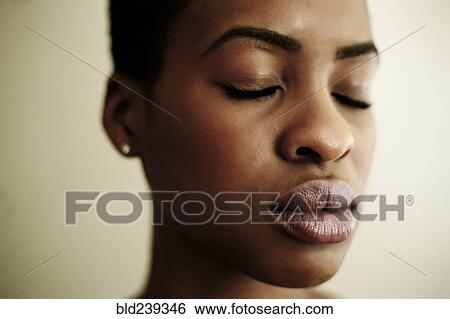Stock Photograph - Portrait of face of Black woman with eyes closed. Fotosearch