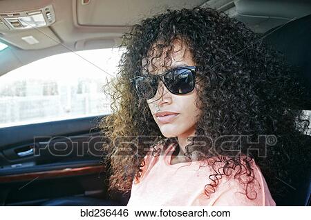 Stock Photograph - Portrait of Hispanic woman driving car. Fotosearch