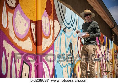 Portrait of man standing on ladder painting mural on wall View Large Photo Image Stock Photo - Portrait of man standing on ladder painting mural on wall. Fotosearch