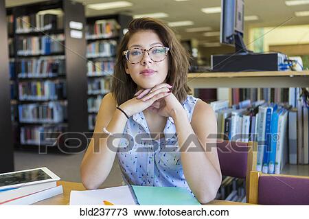 Stock Image - Portrait of Mixed Race girl in library. Fotosearch