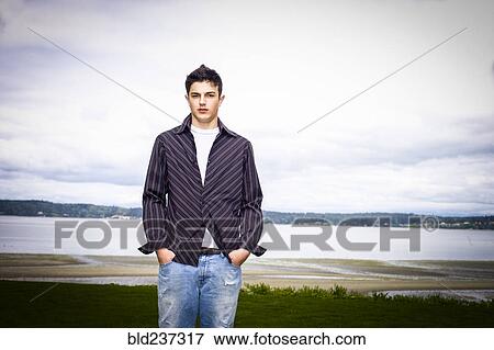 Stock Photo - Portrait of Mixed Race man standing at beach. Fotosearch