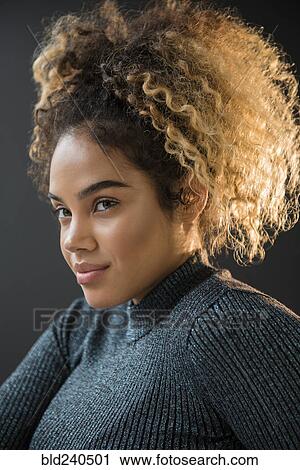Stock Image - Portrait of Mixed Race woman wearing sweater. Fotosearch