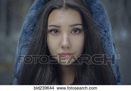 Picture - Portrait of serious Mixed Race teenage girl wearing blue hood. Fotosearch