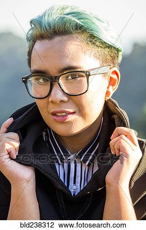 Stock Image - Portrait of smiling androgynous Asian woman. Fotosearch
