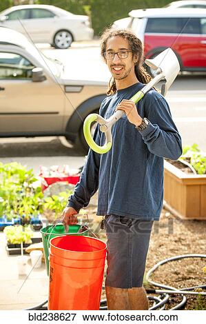 Portrait of smiling Black man holding shovel and buckets View Large Photo Image Stock Photo - Portrait of smiling Black man holding shovel and buckets. Fotosearch