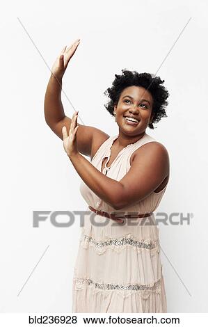 Portrait of smiling Black woman raising arms View Large Photo Image Stock Photo - Portrait of smiling Black woman raising arms. Fotosearch