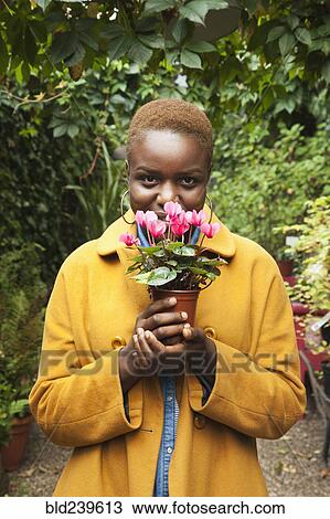 Portrait of smiling Black woman smelling flowers View Large Photo Image Stock Image - Portrait of smiling Black woman smelling flowers. Fotosearch