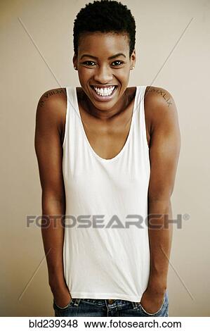 Portrait of smiling Black woman with hands in pockets View Large Photo Image Stock Photo - Portrait of smiling Black woman with hands in pockets. Fotosearch