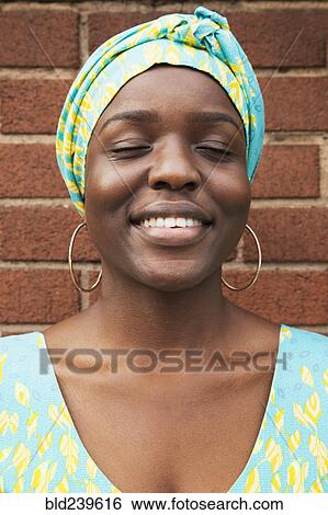 Portrait of smiling Black woman with eyes closed View Large Photo Image Stock Photograph - Portrait of smiling Black woman with eyes closed. Fotosearch