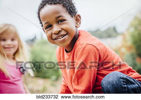 Stock Image - Portrait of smiling boy and girl outdoors. Fotosearch