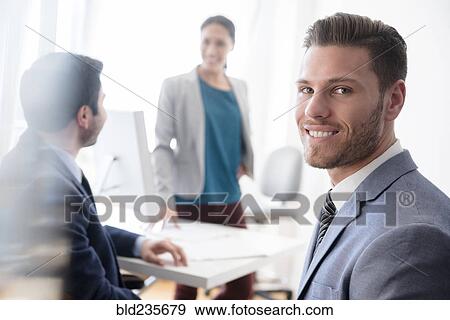 Stock Photo - Portrait of smiling businessman in office. Fotosearch