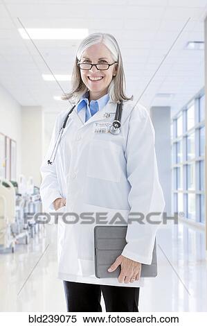 Portrait of smiling Caucasian doctor holding digital tablet View Large Photo Image Stock Photography - Portrait of smiling Caucasian doctor holding digital tablet. Fotosearch