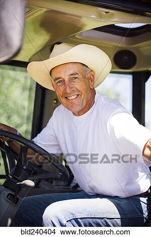 Picture - Portrait of smiling Caucasian farmer in tractor. Fotosearch
