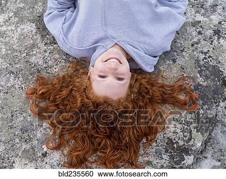 Portrait of smiling Caucasian girl laying on rock View Large Photo Image Stock Image - Portrait of smiling Caucasian girl laying on rock. Fotosearch