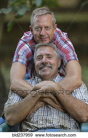 Stock Photo - Portrait of smiling Caucasian men hugging. Fotosearch