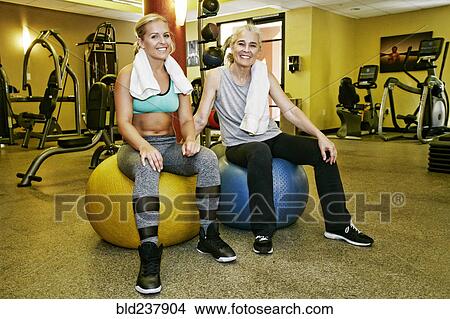 Picture - Portrait of smiling Caucasian mother and daughter in gymnasium. Fotosearch