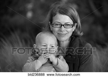 Stock Photo - Portrait of smiling Caucasian mother holding baby son. Fotosearch