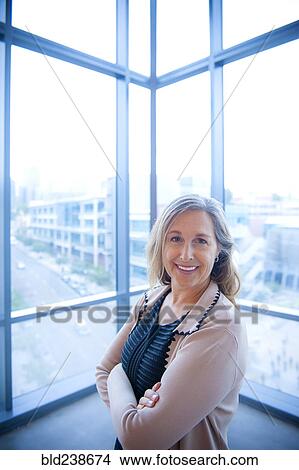 Picture - Portrait of smiling Caucasian businesswoman posing near window. Fotosearch