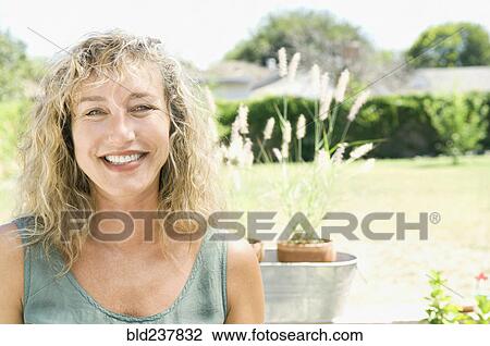 Portrait of smiling Caucasian woman in garden View Large Photo Image Stock Image - Portrait of smiling Caucasian woman in garden. Fotosearch