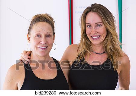 Stock Image - Portrait of smiling Caucasian women hugging. Fotosearch
