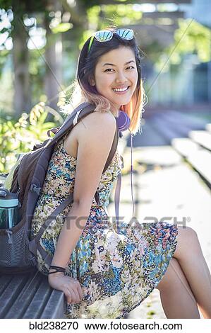 Portrait of smiling Chinese woman on bench wearing backpack View Large Photo Image Stock Image - Portrait of smiling Chinese woman on bench wearing backpack. Fotosearch