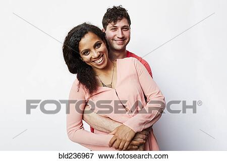 Stock Photo - Portrait of smiling couple hugging. Fotosearch