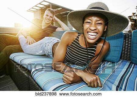 Portrait of smiling couple on rooftop sofa View Large Photo Image Stock Photo - Portrait of smiling couple on rooftop sofa. Fotosearch