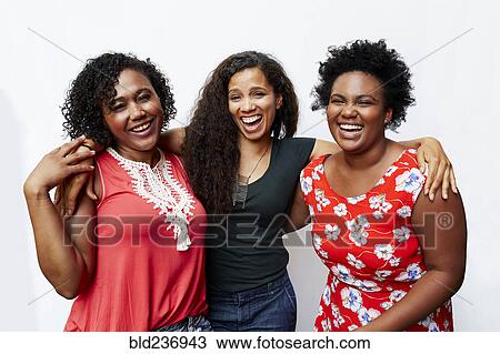 Stock Image - Portrait of smiling friends hugging. Fotosearch