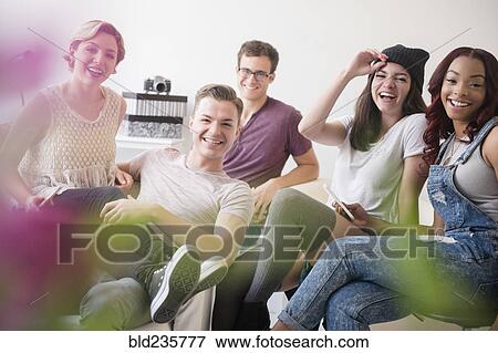 Portrait of smiling friends in livingroom View Large Photo Image Stock Photo - Portrait of smiling friends in livingroom. Fotosearch