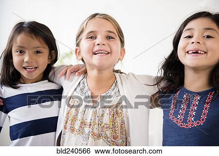Stock Photograph - Portrait of smiling girls hugging. Fotosearch