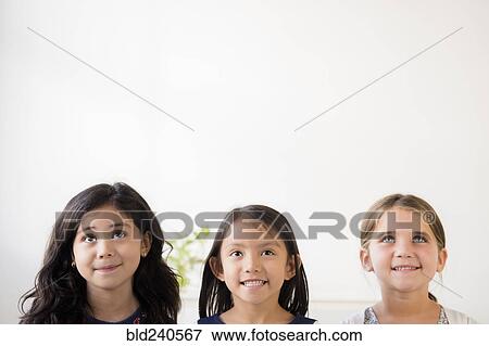 Portrait of smiling girls looking up View Large Photo Image Stock Photo - Portrait of smiling girls looking up. Fotosearch