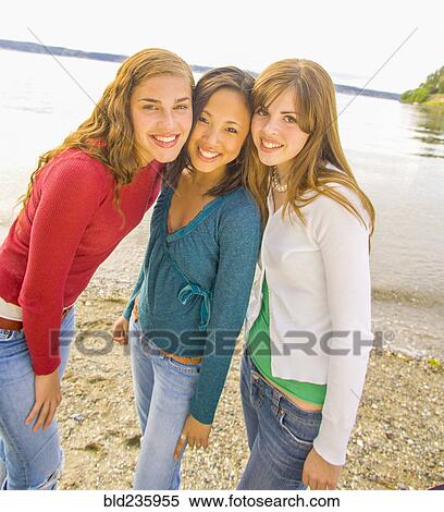 Portrait of smiling girls posing at beach View Large Photo Image Stock Photography - Portrait of smiling girls posing at beach. Fotosearch