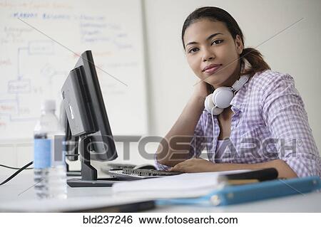 Stock Photograph - Portrait of smiling Hispanic woman in computer lab. Fotosearch