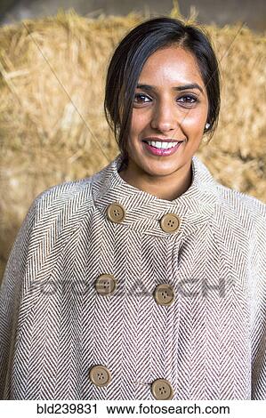 Stock Image - Portrait of smiling Indian woman wearing poncho. Fotosearch