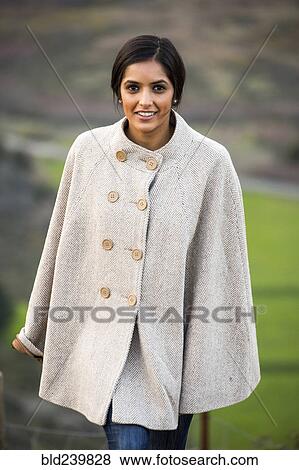 Stock Photo - Portrait of smiling Indian woman wearing poncho. Fotosearch